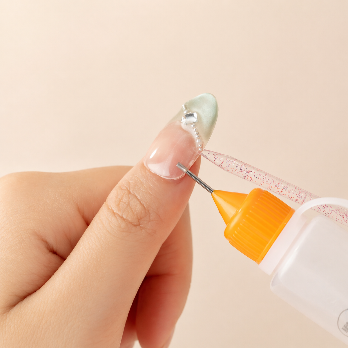 Applying remover into the gap while gently removing a press-on nail