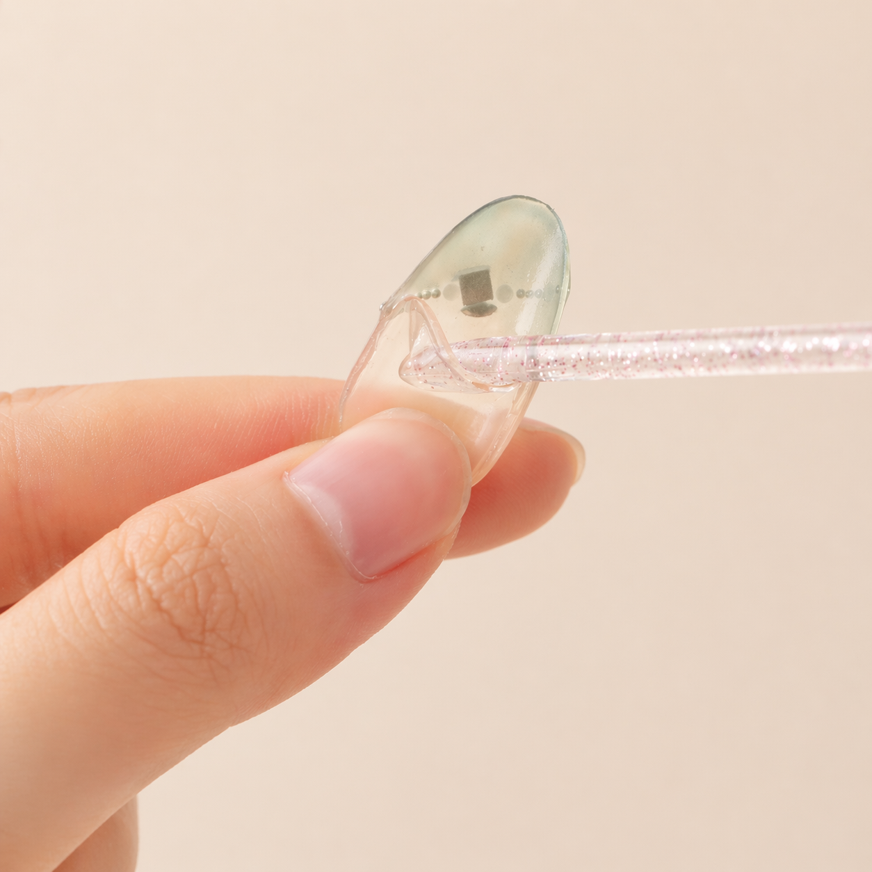 Gently removing leftover adhesive from the inside of a press-on nail with a stick